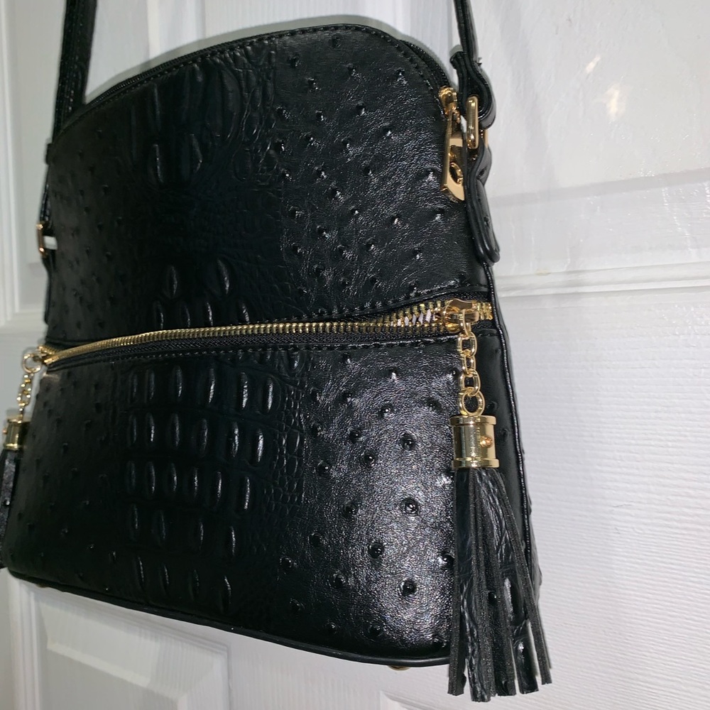 A black crossbody with tassels and 3 pockets